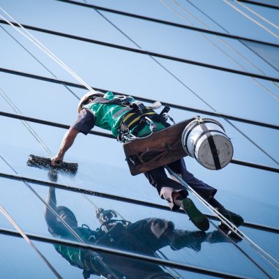 group of workers cleaning windows service on high rise building